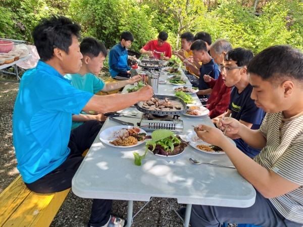 다 함께 모여 맛있게 삼겹살을 구워먹는 모습